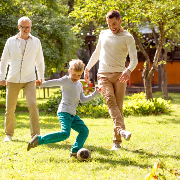 happy family playing football outdoors